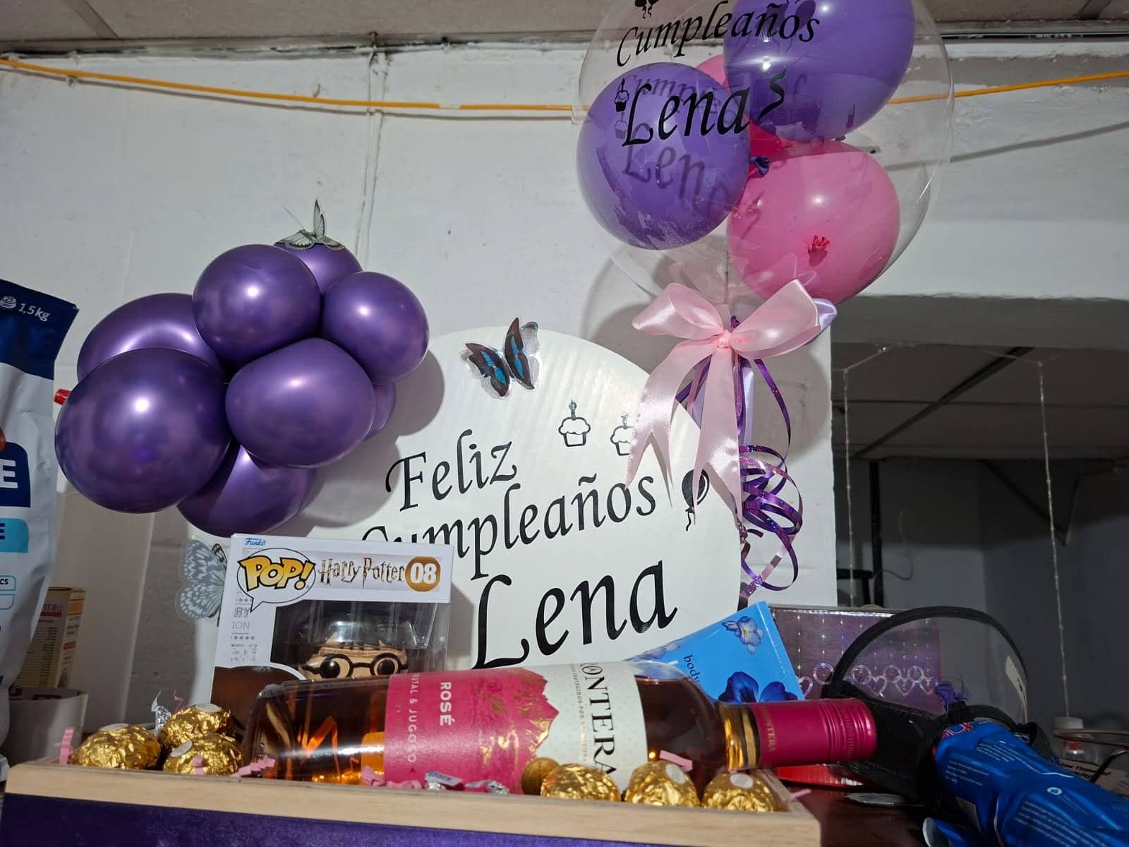 Detalle de arreglo con cupcake de regalo, globo burbuja transparente con confeti y vino
