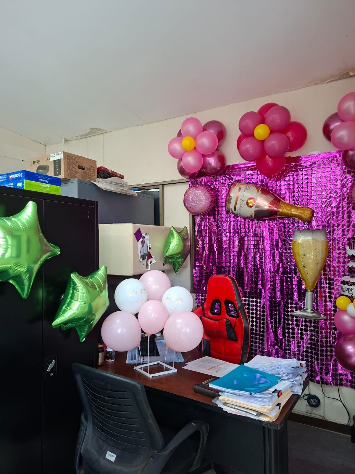 Silla decorada con globos rosados, estrellas verdes y banner de Feliz Cumpleaños para la festejada