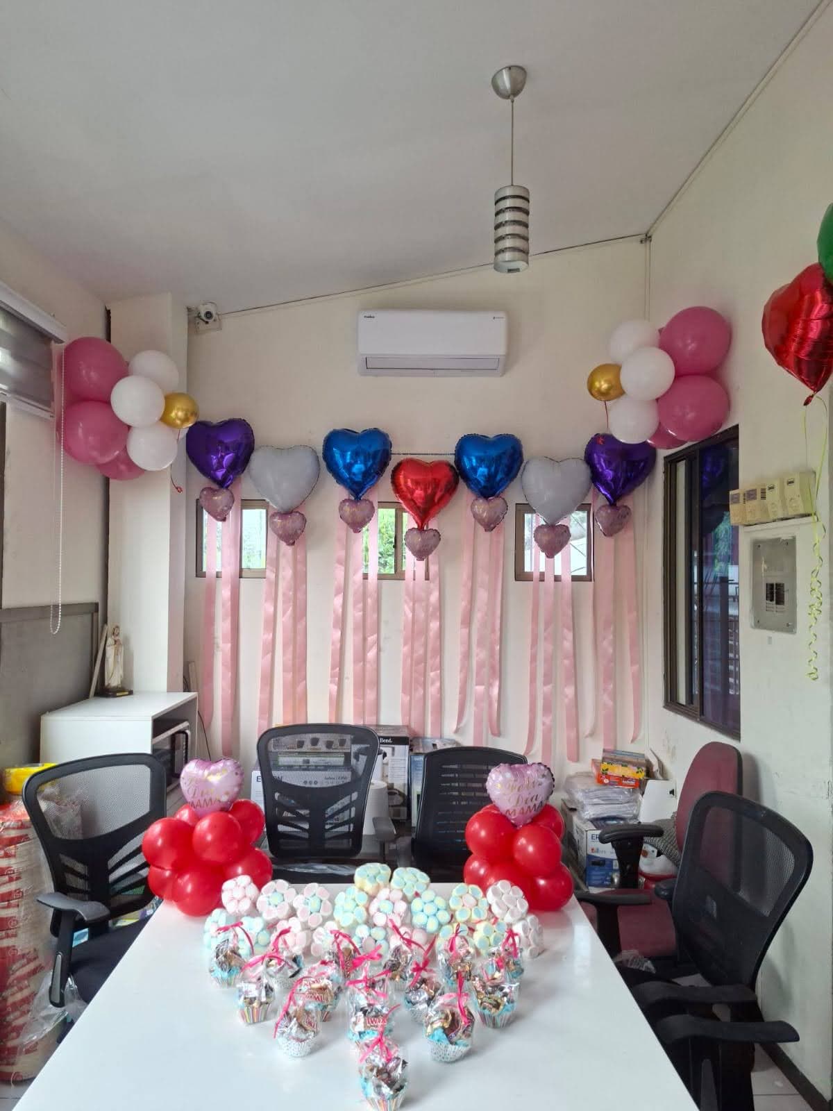 Arco de globos rosa y blanco con detalles en corazones y mesas decoradas para una ocasión especial