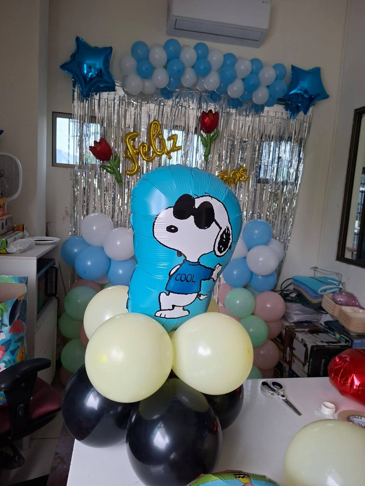 Globo gigante de Snoopy con lentes de sol rodeado de globos pastel para cumpleaños infantil