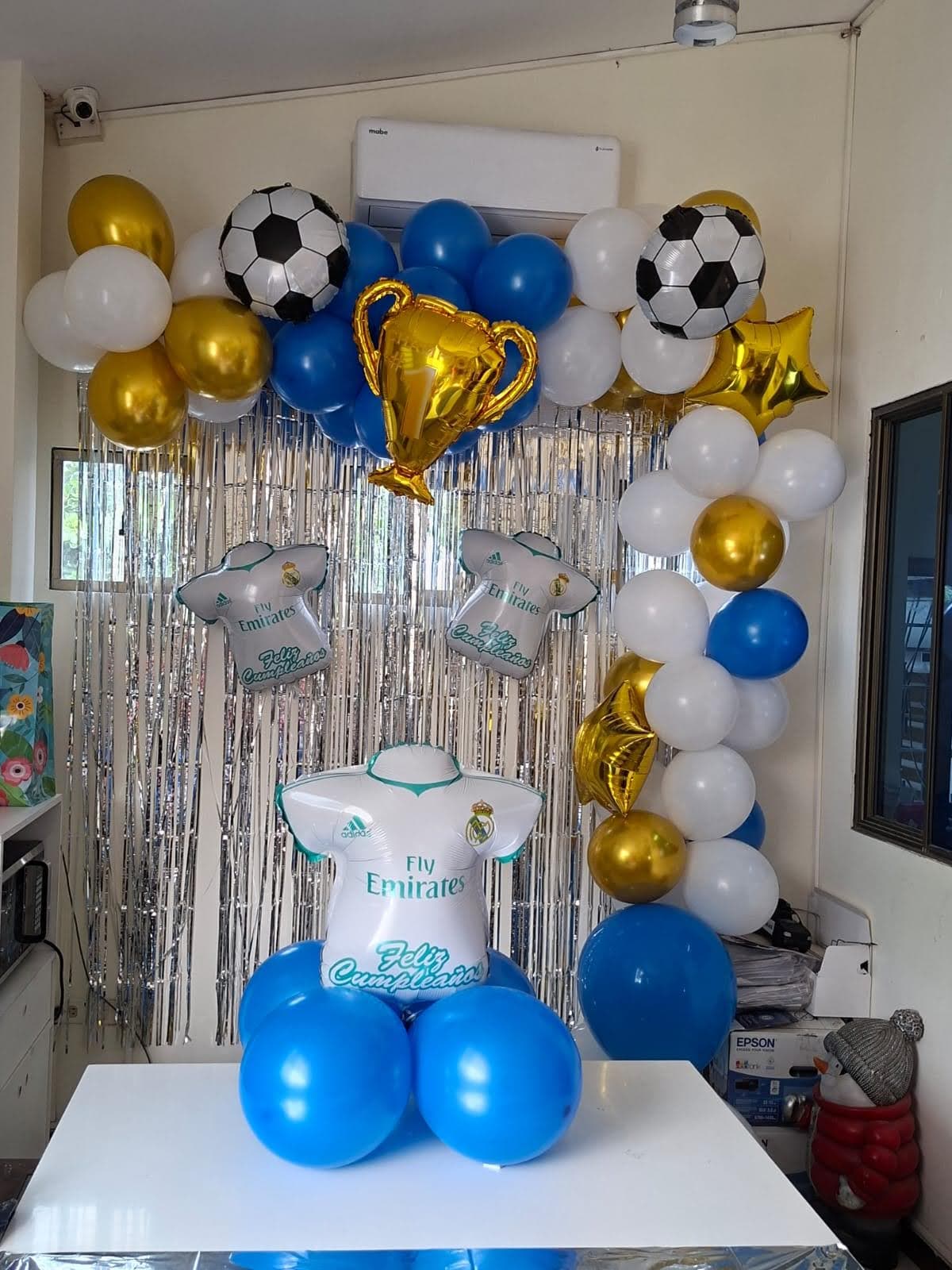 Decoración infantil con temática de Real Madrid: globos azules, blancos, dorados y trofeos
